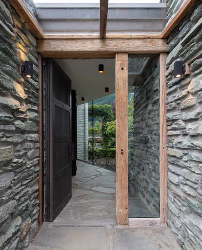 Stone-walled entrance beneath a glazed timber canopy