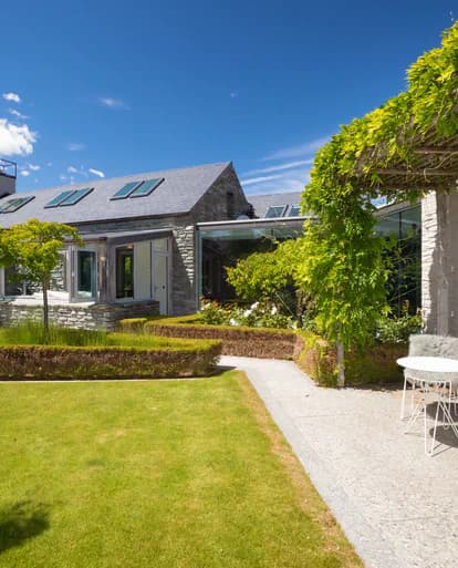 Landscaped garden and lawn beside the stone-clad home
